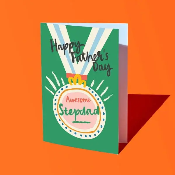 A green Fathers Day card reading Happy Father’s Day Amazing Stepdad, illustrated with a medal design and displayed against a bright orange background.